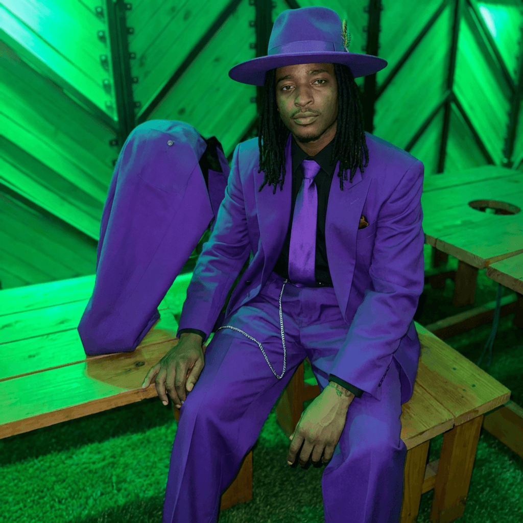put man sitting down in purple outfit matching lighting and stance