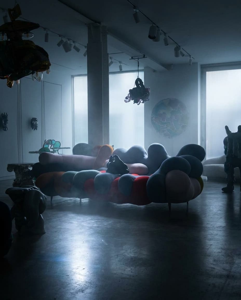 Mysterious teaser frame for Siam: dramatic medium-pace lighting in HYPE BEAST COMBO, deep shadows with a single rim-light hinting at a product silhouette, premium gradient background, lens flare, atmospheric mist,  brand voice, ultra-detailed product-photography aesthetic, no readable text — preserve EXACT location identity: contemporary art gallery showroom with sculptural furniture installations (indeterminate) — mixed directional and diffuse cool daylight light — white concrete columns, polished concrete floors.

Keep the product as: product. Do not substitute the product with a different format (jar instead of bottle, tub instead of tin, plastic instead of glass, opened pack instead of sealed, etc.). Keep container kind, color, label, and visible text identical.