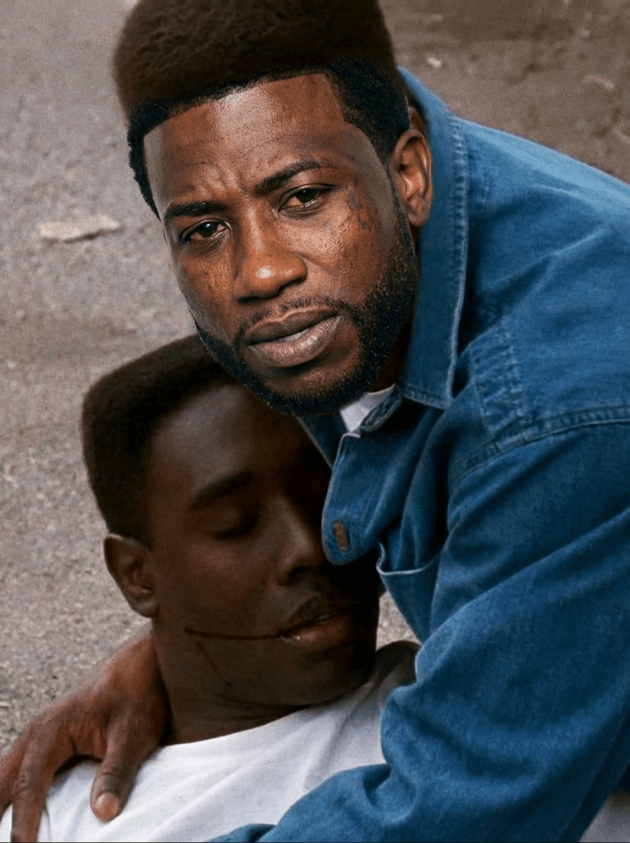 Use the provided image as the base reference.

🎯 CORE TASK:

Perform a high-precision face and identity swap on the man wearing the white shirt.

🧍‍♂️ SUBJECT TRANSFORMATION:
Replace the face of the man in the white shirt with a realistic version of Gucci Mane (rapper)
Maintain:
Same pose (holding the other person)
Same body position and angle
Same clothing (white shirt — DO NOT change outfit)
Same emotional intensity and expression
FACIAL DETAILS:
Apply Gucci Mane’s:
Facial structure
Skin tone
Beard/goatee
Hairline
Expression should match the scene:
distressed, emotional, intense
⚠️ STRICT RULES:
DO NOT change:
Background or environment
Lighting or shadows
Camera angle or framing
The second person in the image
Preserve:
Original cinematic realism
Natural blending of skin tones and lighting
Emotional tone of the scene
🎬 STYLE:
Realistic movie still
Natural lighting
Slight film grain
No cartoon or AI distortion
