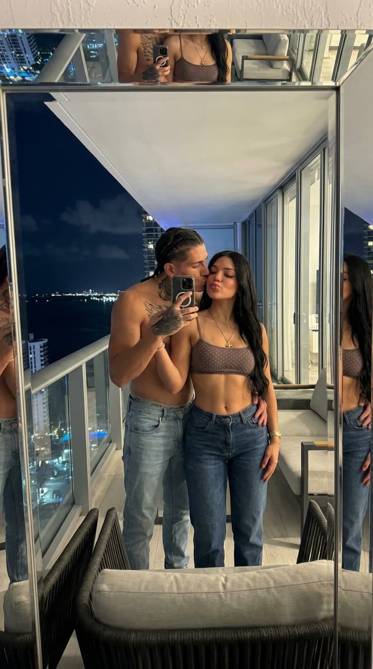 i would like to have this exact same guy and the girl in the exact same pose but instead of taking a mirror pic in the bathroom make a mirror pic in the top of a miami balcony penthouse with city view at night
