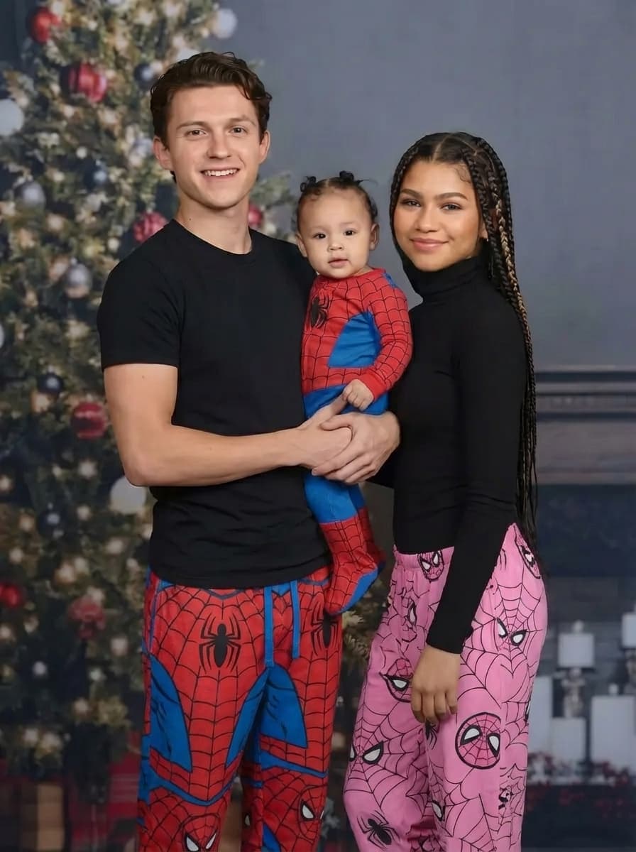 only change the pants the man and woman are wearing to be spiderman themed pants the girl has pink spiderman pants and the man with regular spiderman color scheme pants. and make the babies pajamas be spiderman themed as well. do not change anything else at all. make sure the quality pose esthetic and likness all remains the exact same