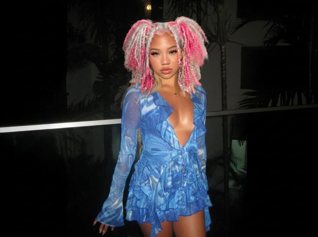 Replace the face, skin tone, and hairstyle of the blonde hair woman with the pink and white hair woman reference person, while keeping the original pose, body, outfit, lighting, and background unchanged. Ensure the result looks natural, realistic, and seamlessly blended. 