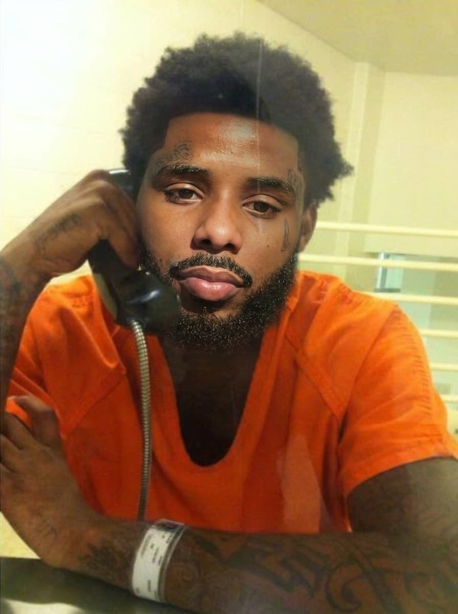 replace the man on phone in jail face with pooh shiesty (refence man) keeping lighting changing nothing else keep reference man facial hair in swap