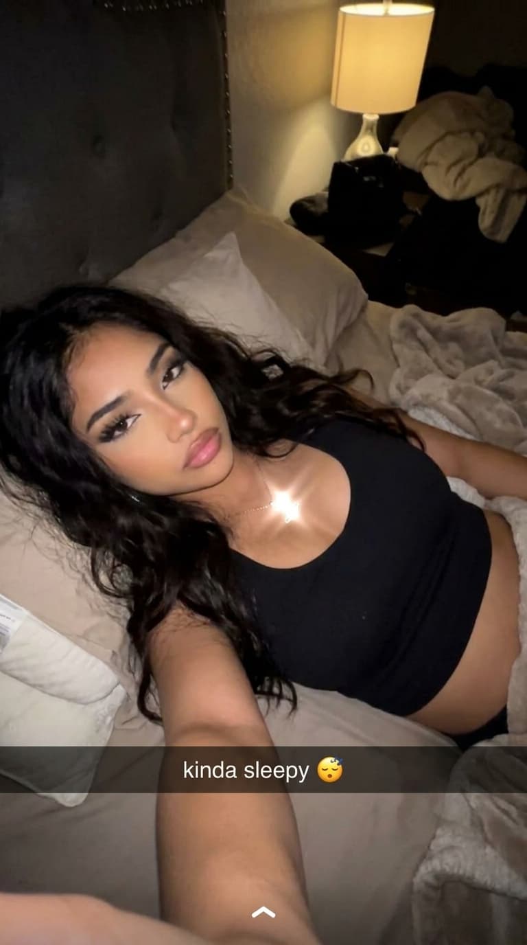 Make a unique combination of these females on a bed selfie like Snapchat baddies upward postion while she laid back in bed with a darker background quality can be little shaky but clear like a realistic bed selfie would b but nonchalant expression 